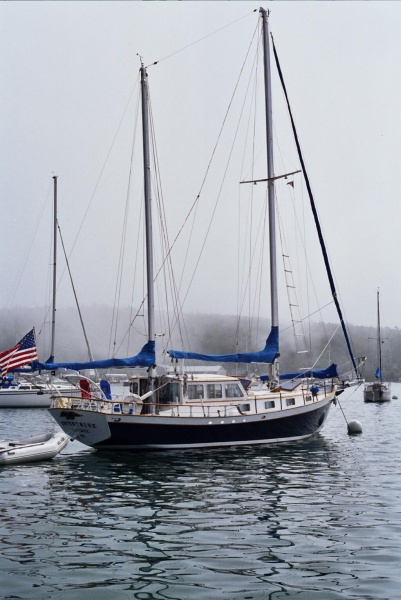 Fog slowly lifts as the Enterprise sits quietly on a mooring, near the Tugboat Inn, in Boothbay Harbor, Maine.